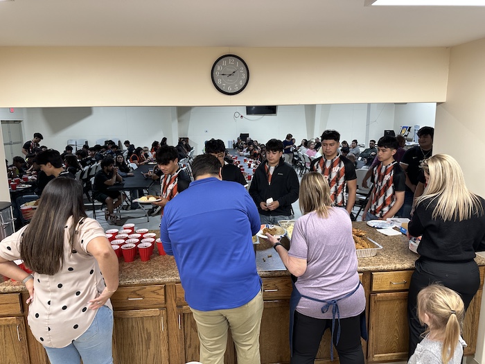 A group of people standing around a counter.