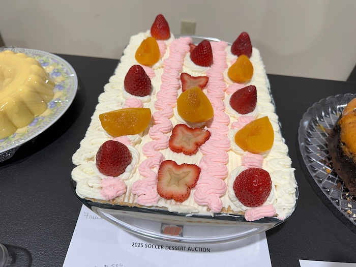 A cake with strawberries and oranges on top of it.