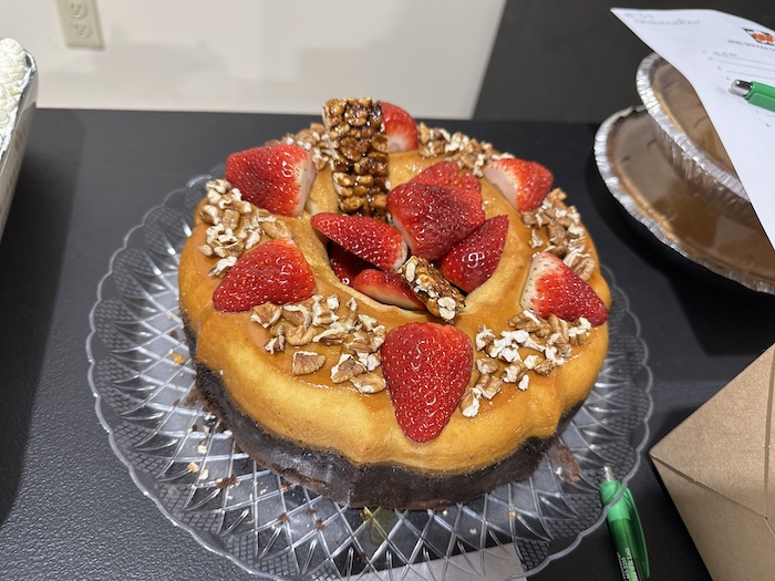 A cake with strawberries and nuts on top of it.