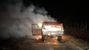 A truck that is on fire and smoking.