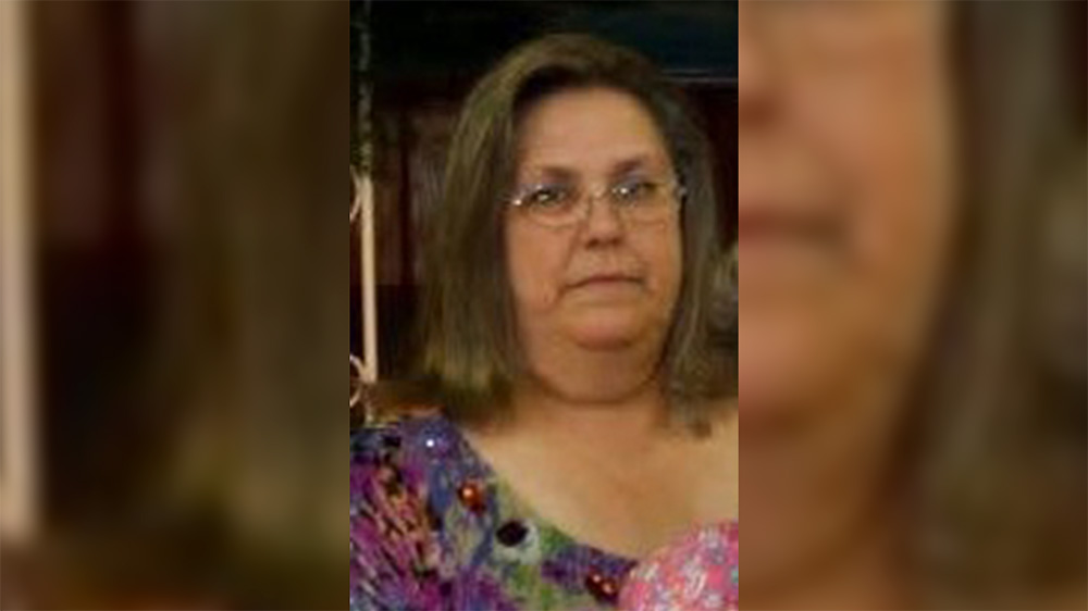 A woman with glasses and a purple shirt