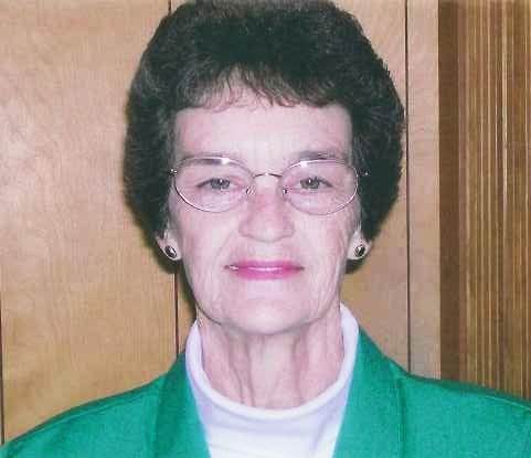 A woman in glasses and green jacket.