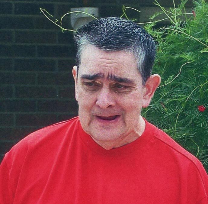 A man in red shirt with eyes closed.