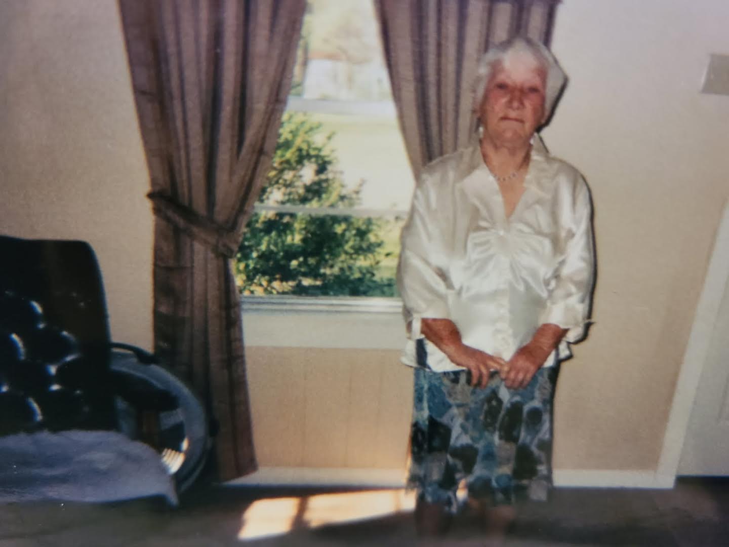 A woman standing in front of a window.