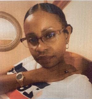 A woman with glasses and a watch is posing for the camera.