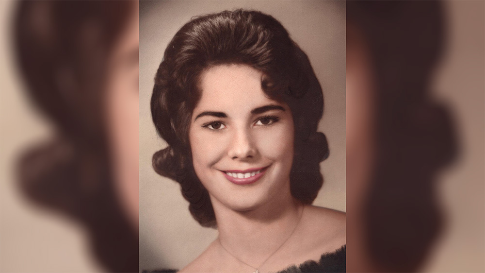 A woman with long hair and a necklace.