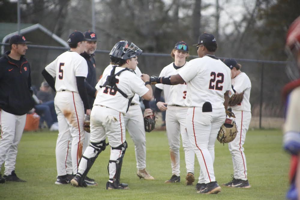 A group of baseball players standing on top of a field.