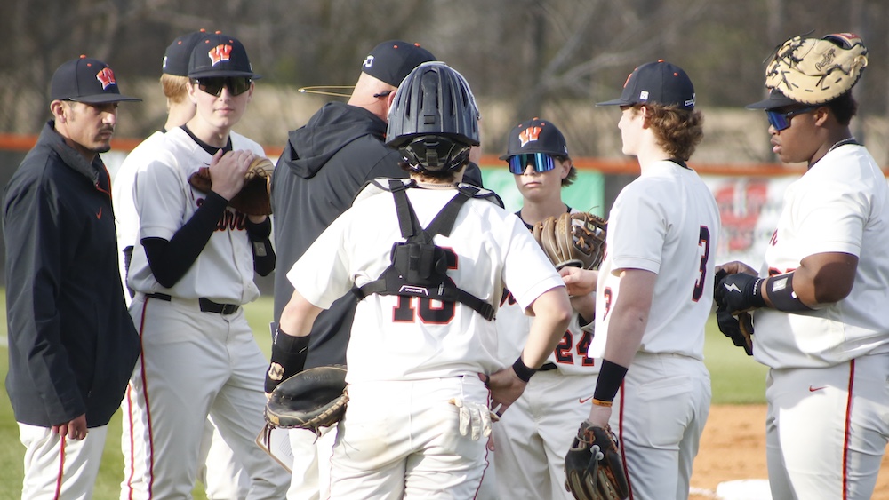A group of baseball players standing on top of a field.