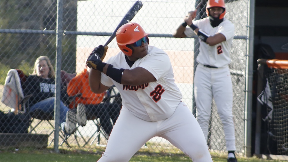 A baseball player is getting ready to hit the ball.