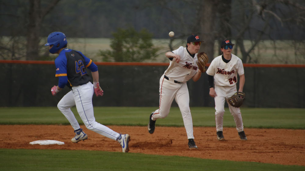 A baseball player is running to catch the ball.