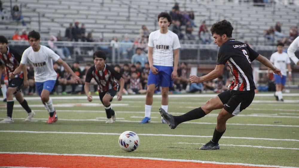 A group of young men playing soccer on a field.