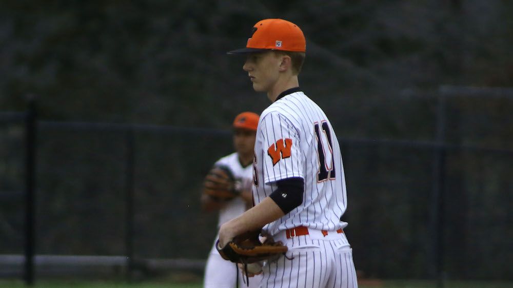 A baseball player in the middle of his pitch.