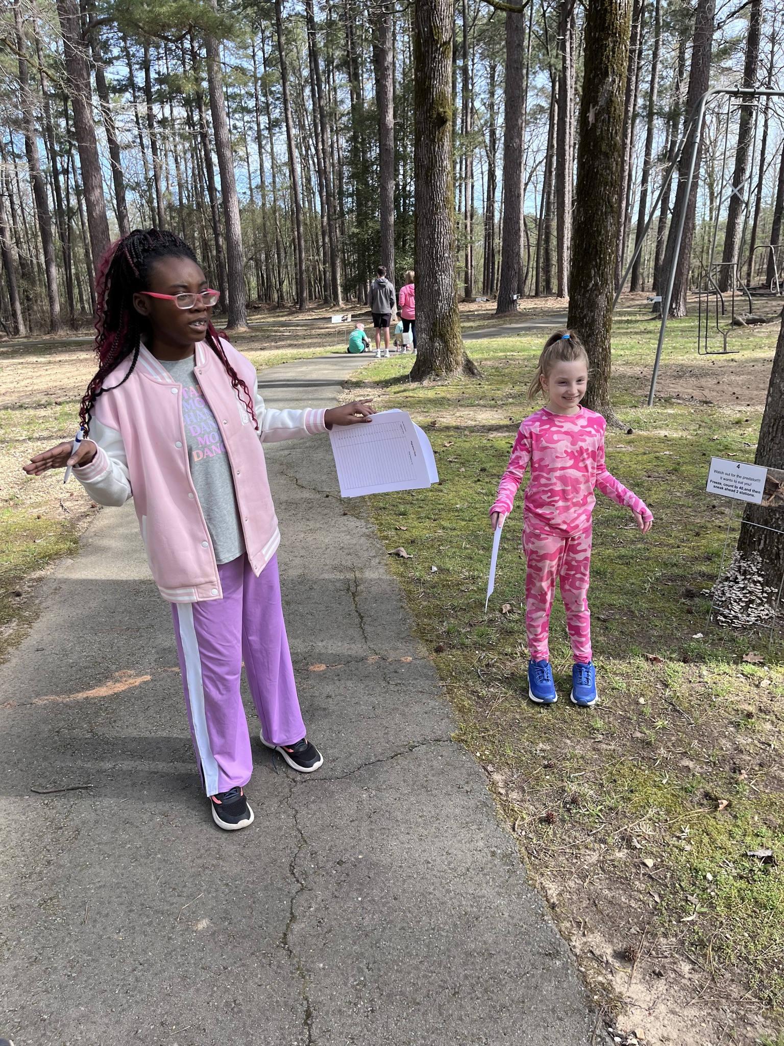 Two girls are playing frisbee in the park.