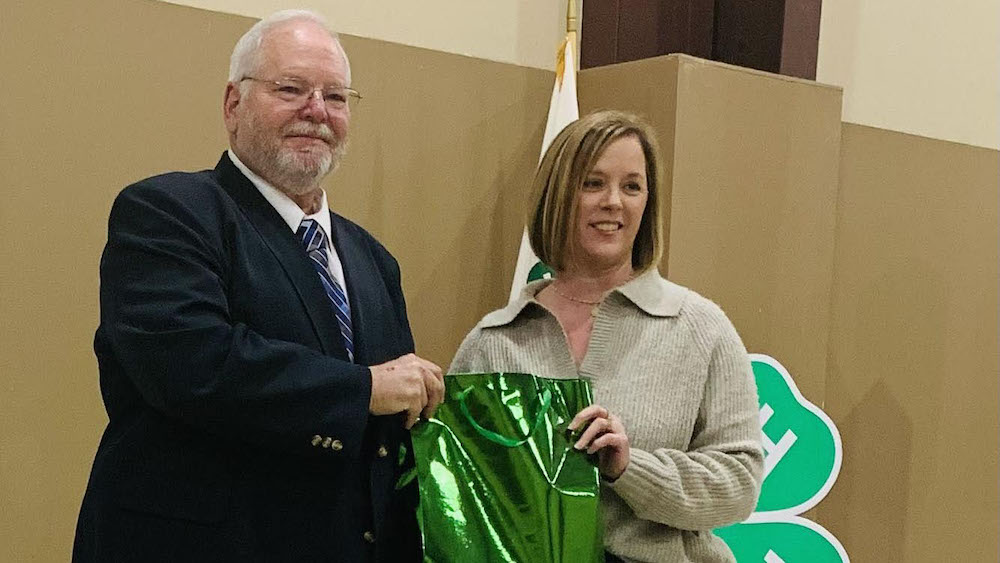 A man and woman holding onto a green bag