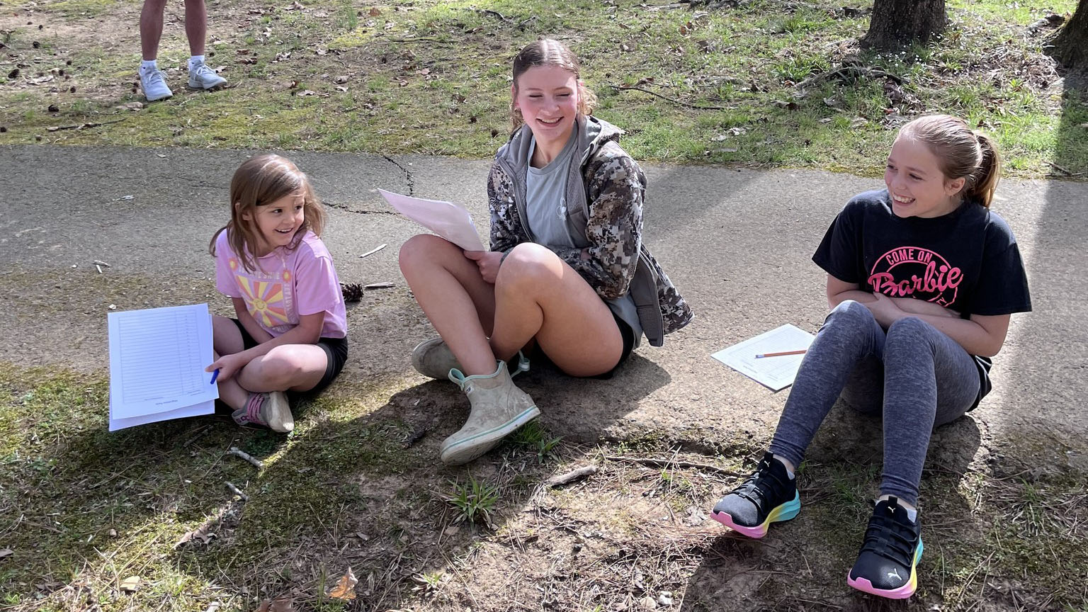 A group of young people sitting on the ground.