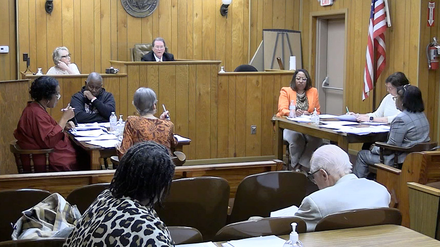 A group of people sitting in front of a judge.