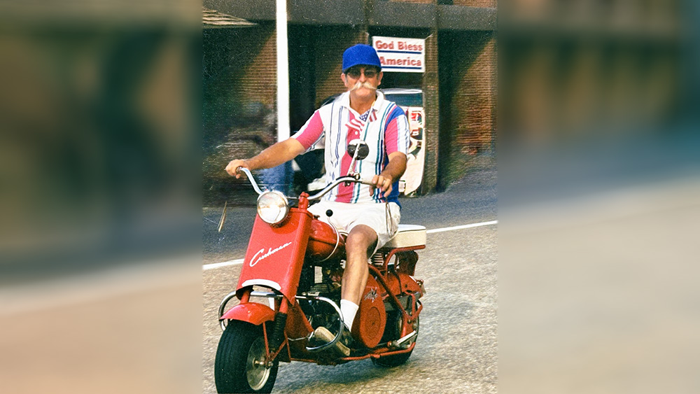 A man riding on the back of a red motorcycle.