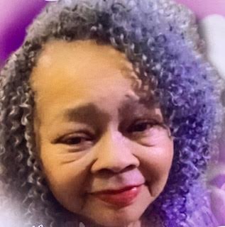 A woman with purple hair and white skin.