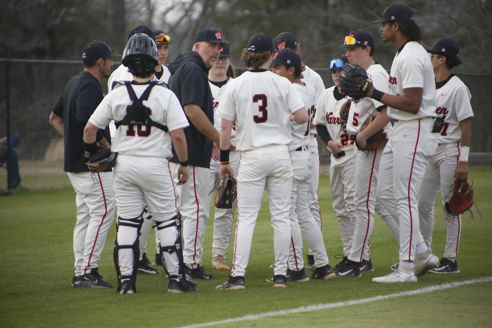 A group of baseball players standing on top of a field.