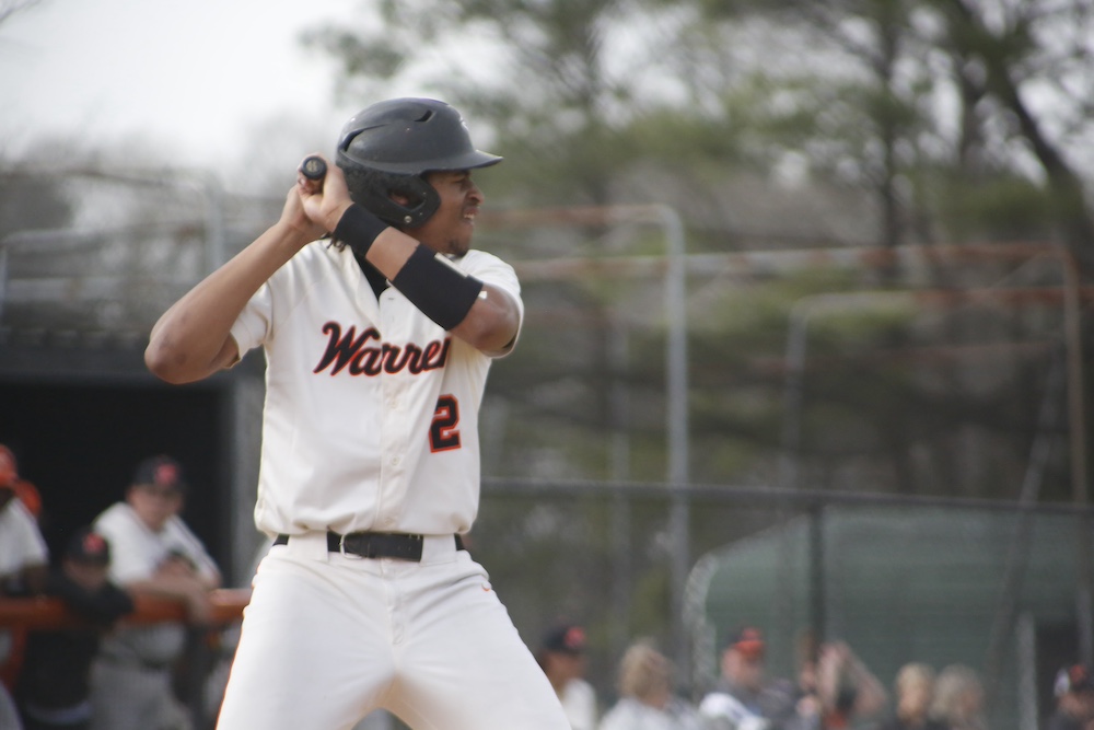 A baseball player is holding his bat ready to swing.