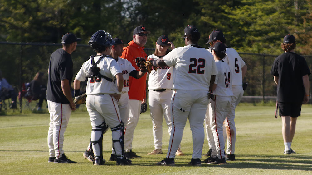 A group of baseball players standing on top of a field.
