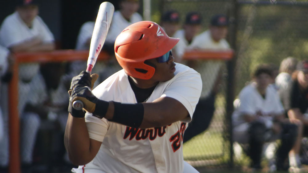A baseball player is swinging at the ball.