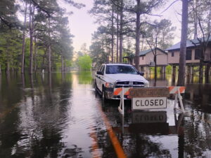 A truck is parked in the middle of a flooded street.