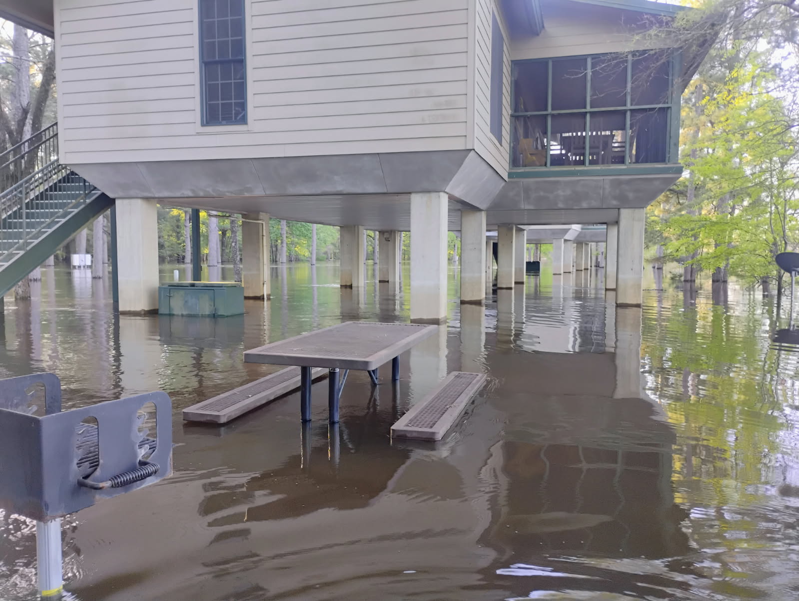 A flooded area with tables and benches in the middle.