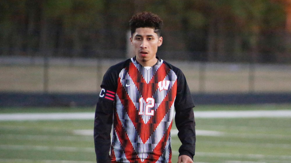 A young man in red and black soccer uniform.