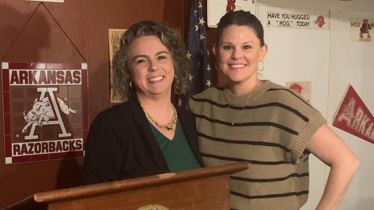 Two women standing next to each other in front of a podium.