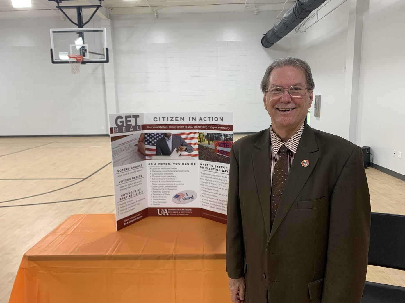 A man standing in front of a poster.