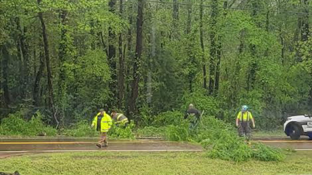 A group of people walking on the side of a road.