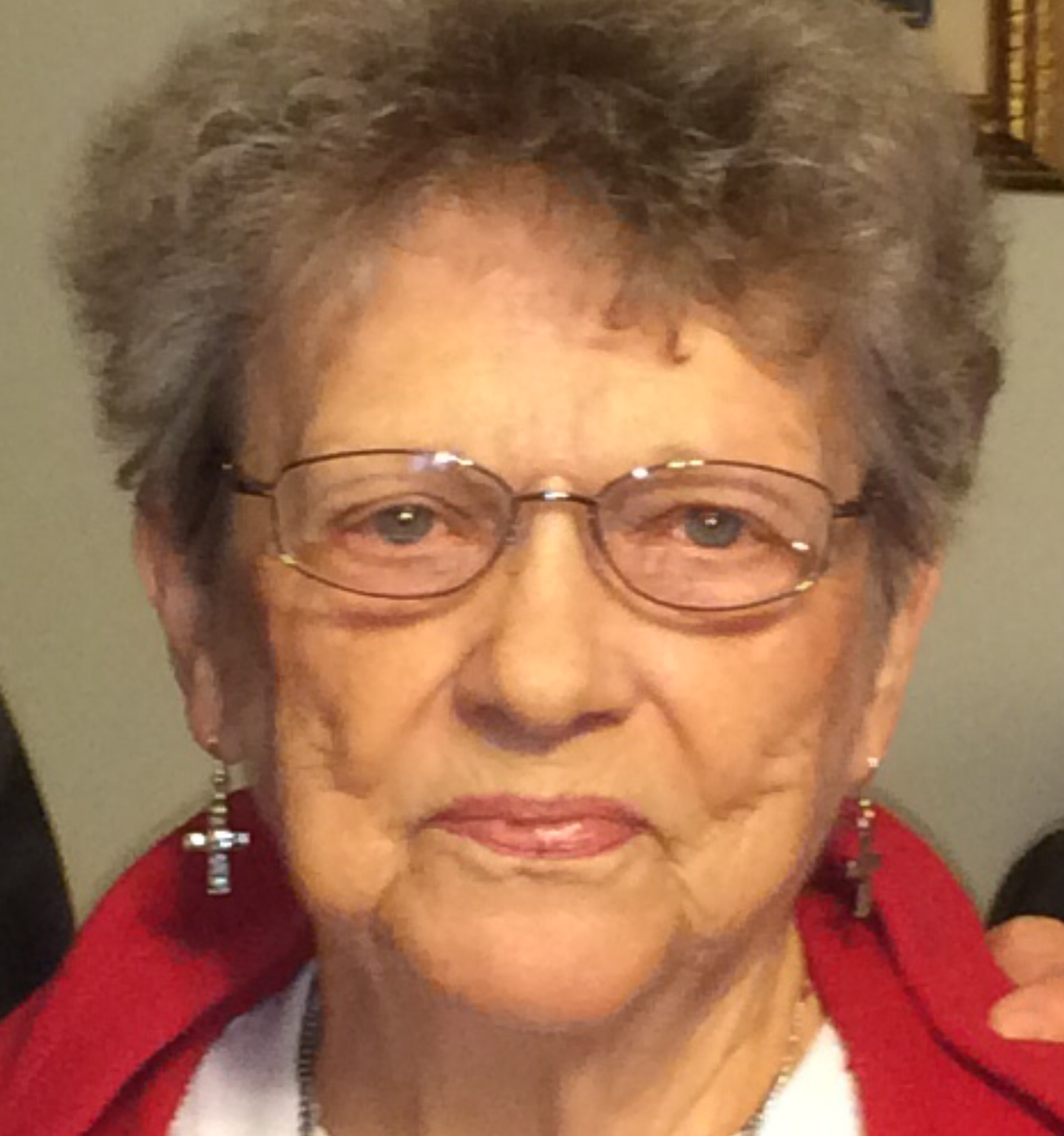 A woman with glasses and a red jacket.