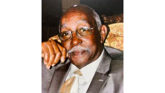 A man in a suit and tie sitting down.