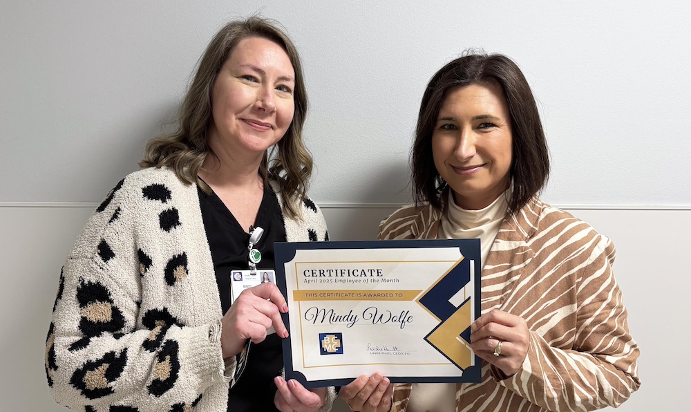 Two women holding a certificate of merit