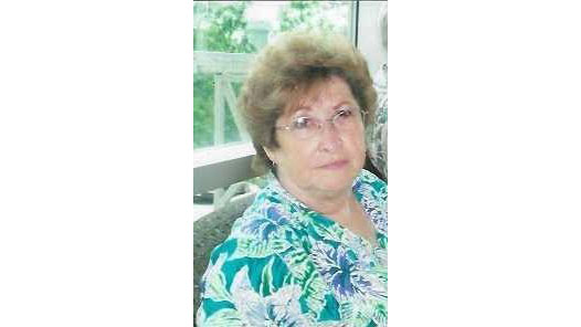 A woman with glasses and a floral shirt.