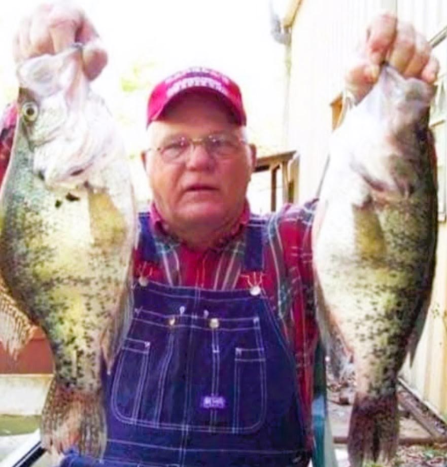 A man holding two fish in his hands.