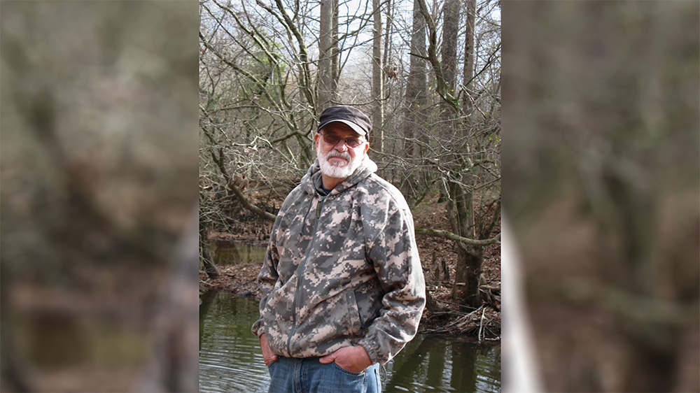 A man standing in front of some water