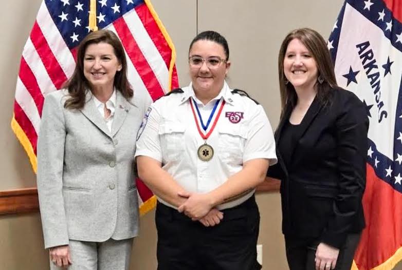 Three women standing next to a man in uniform.
