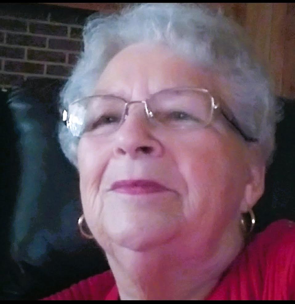 A woman with glasses is sitting in a chair.