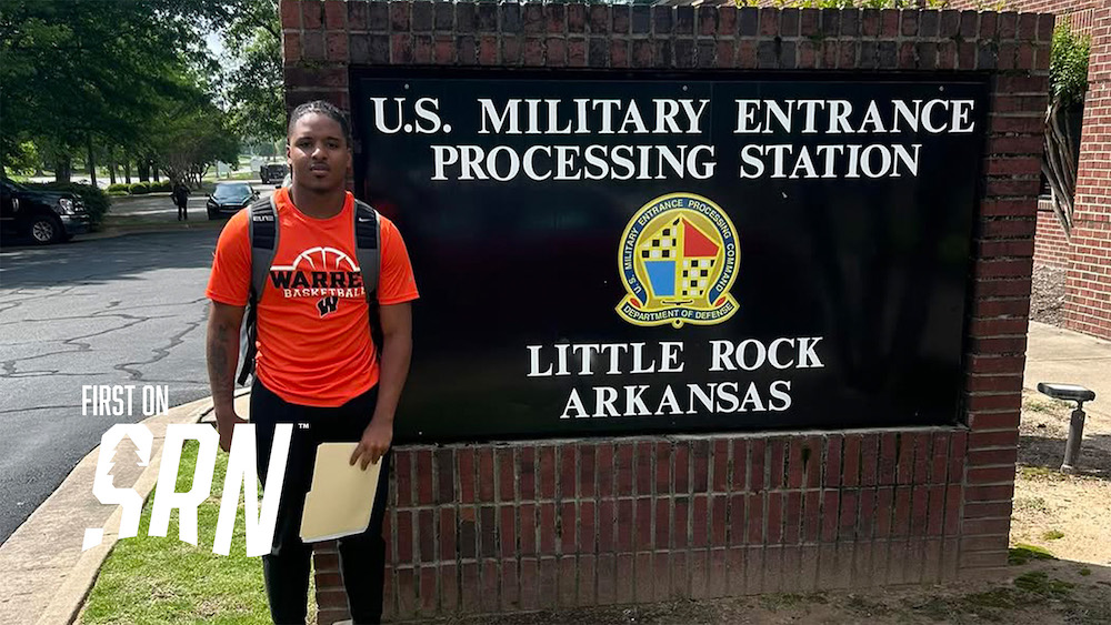 A person standing in front of a sign.